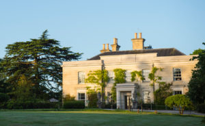 The Limewood Hotel exterior surrounded by large trees and blue skies