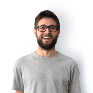 A bearded man with short dark hair and black rimmed glasses