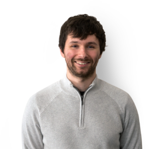 Man wearing grey sweater, with short black hair and facial hair